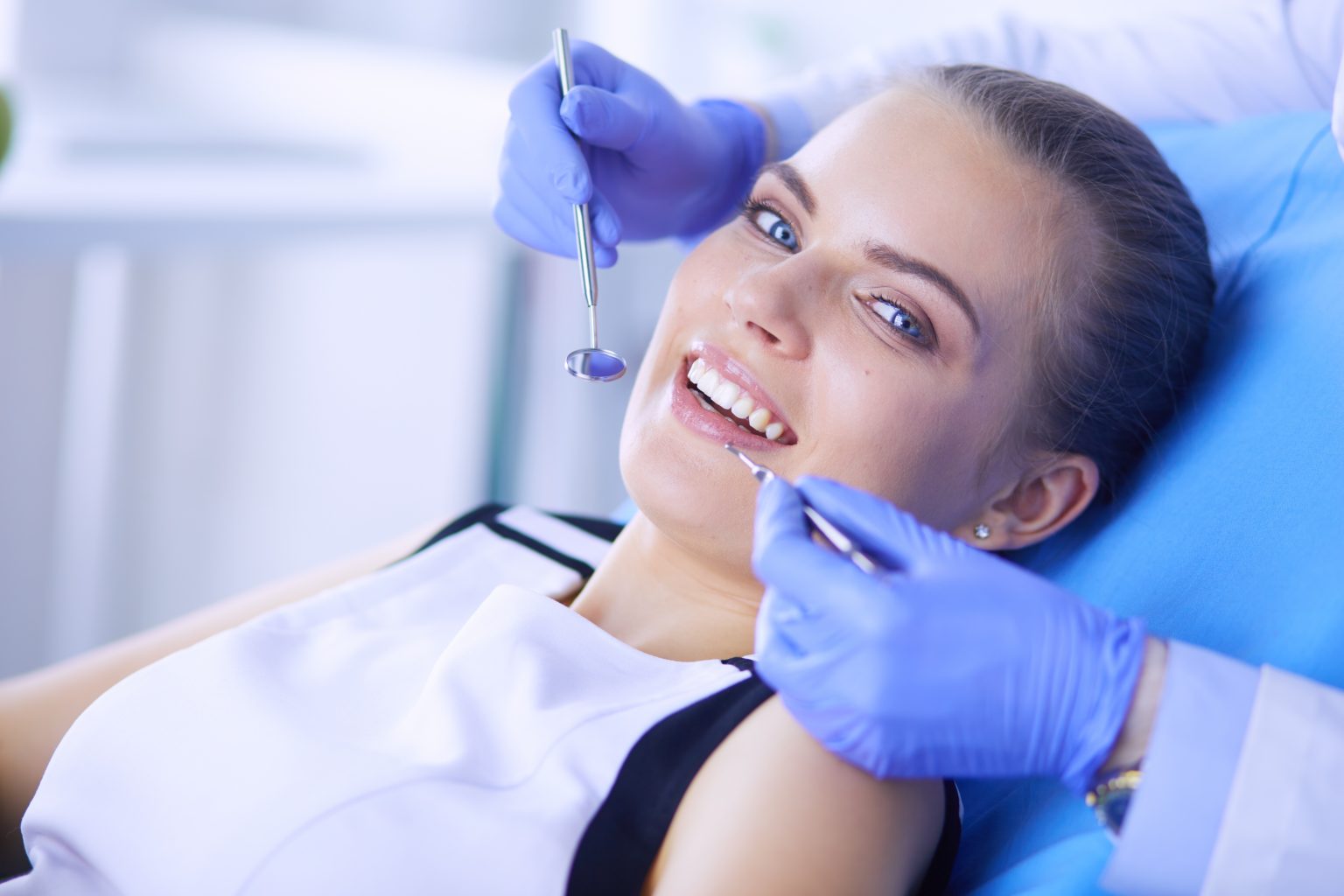 Young Female Patient With Open Mouth Examining Dental Inspection At Dentist Office.